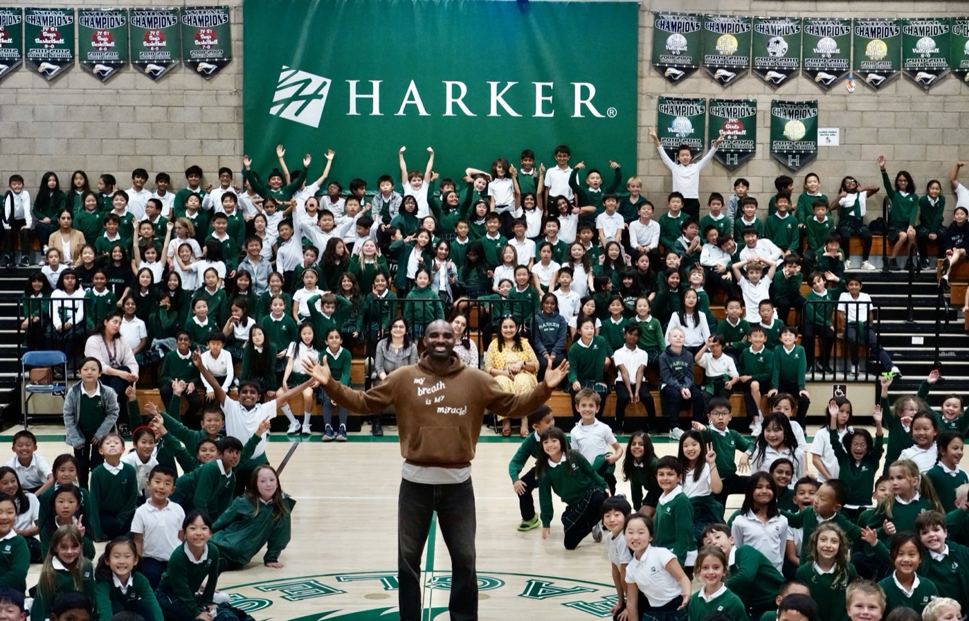 Preston Pollard in front of a packed school gym, students cheering behind him